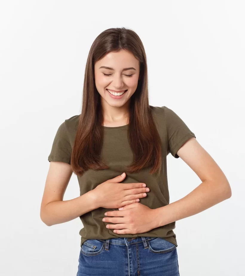 Smiling woman with hand on stomach — representing colon hydrotherapy for natural detox, improved digestion, and gut wellness.