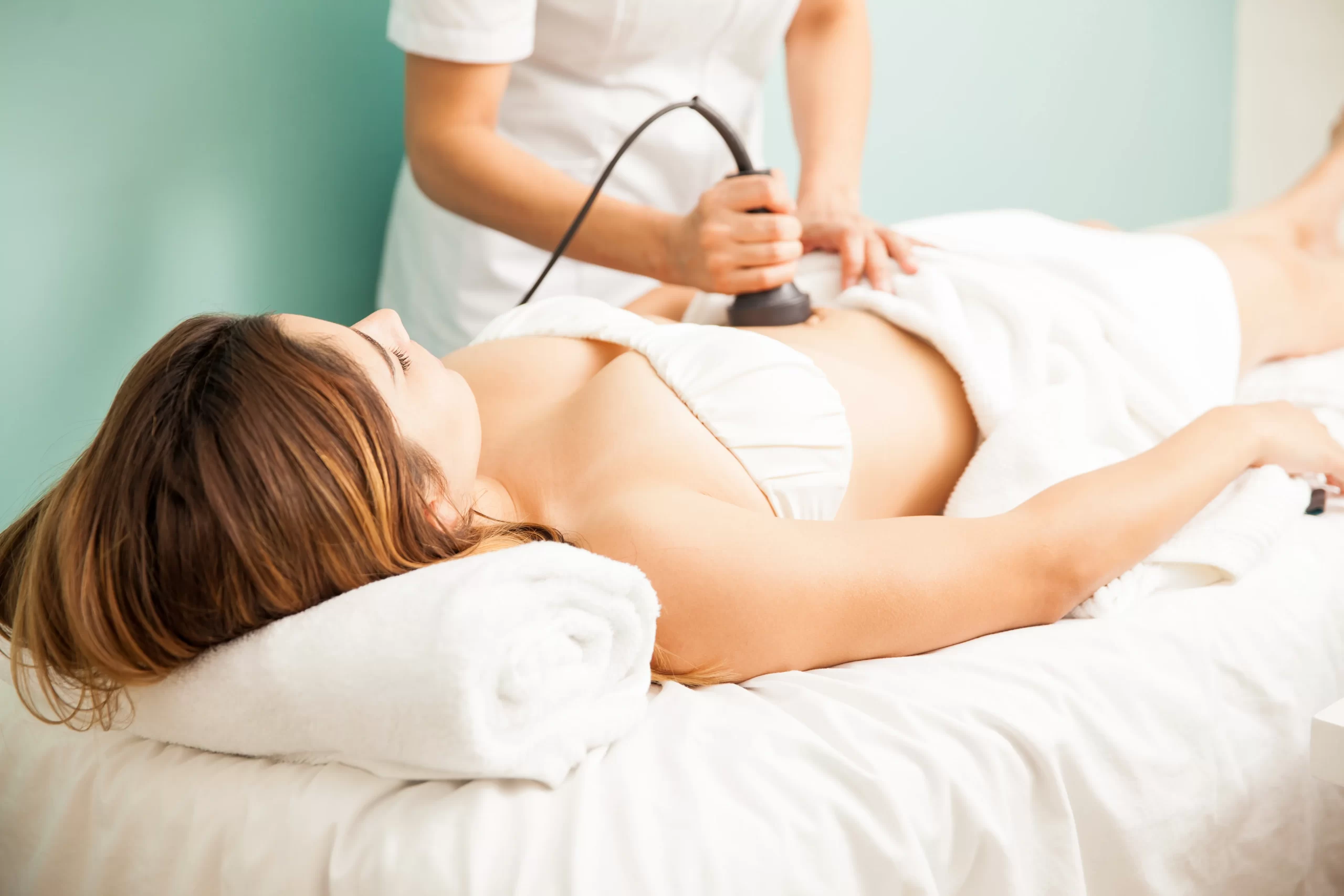 Therapist applying low level laser therapy on client’s stomach — illustrating how LILT enhances blood circulation, detox, and tissue recovery through light-based treatment.