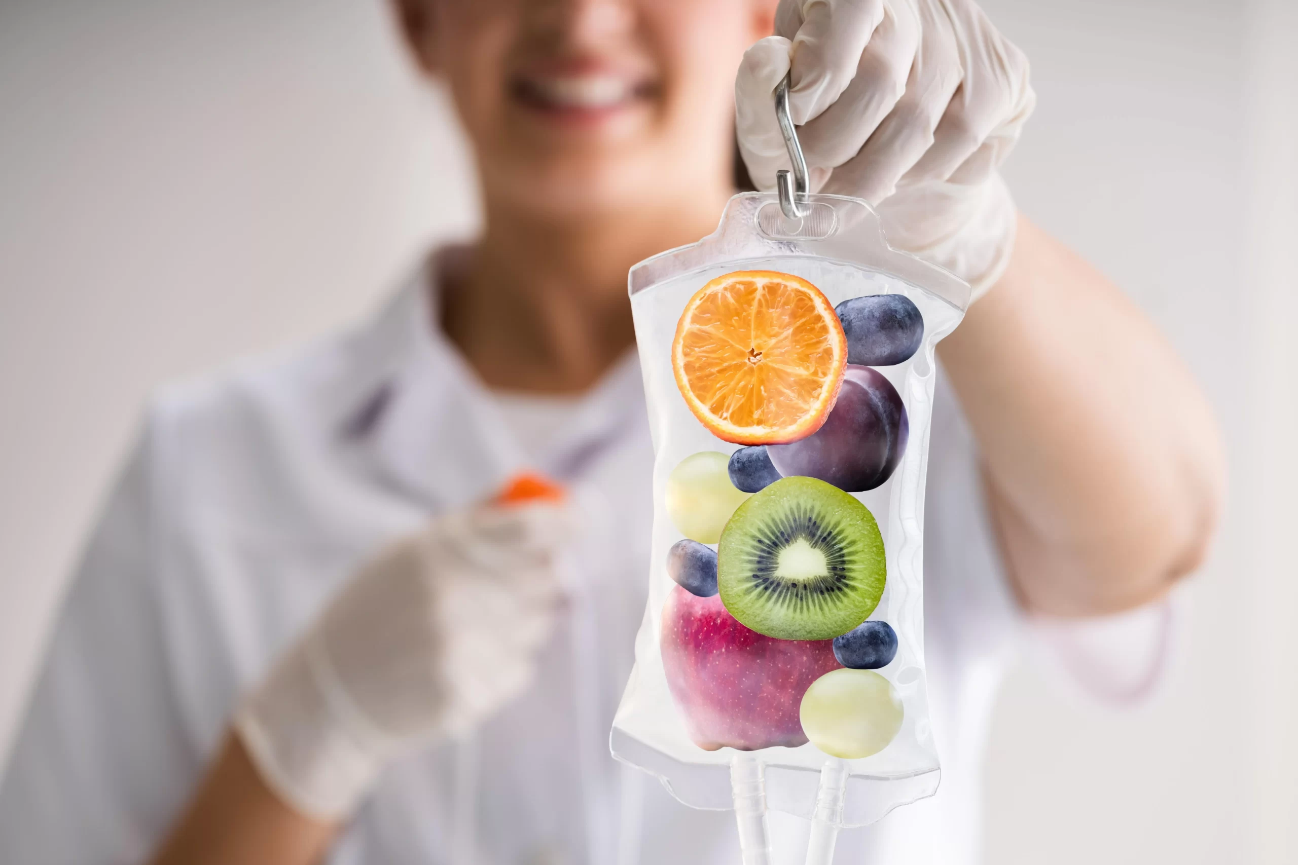 IV drip with fruits in the background, representing a powerful mix of vitamins and antioxidants in infusion therapy for improved energy, immunity, and vitality.