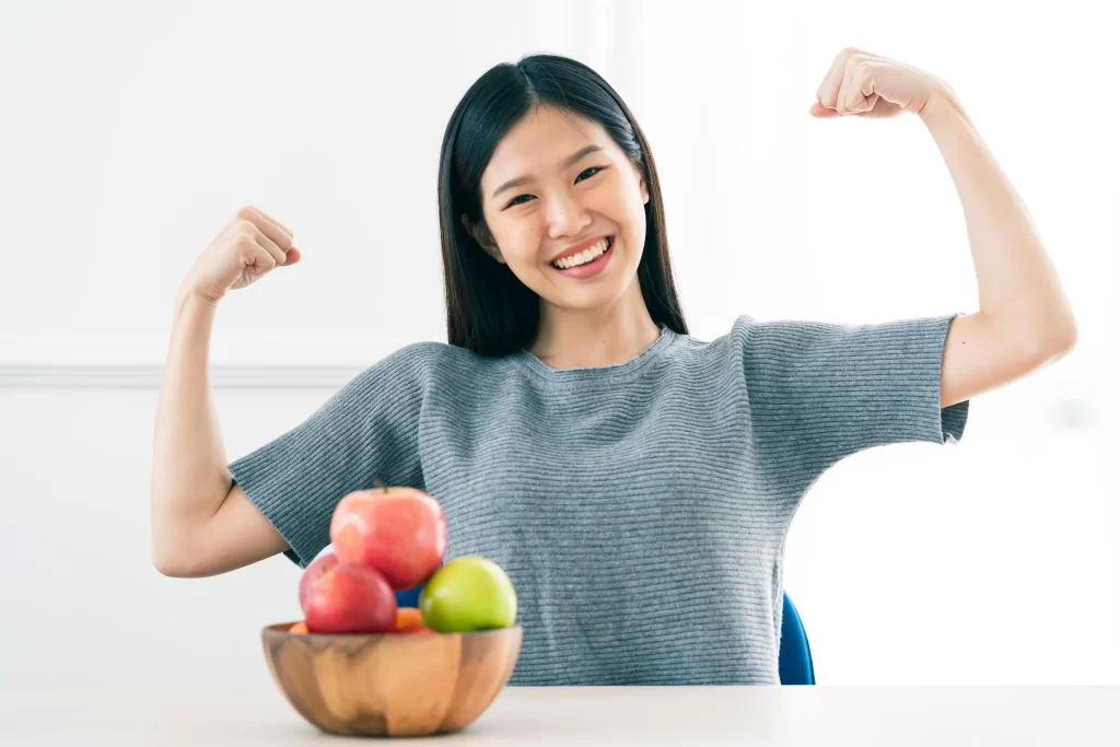 Young woman with fruits showing confidence and wellness — representing women’s health enhancement through natural nutrition and lifestyle balance.