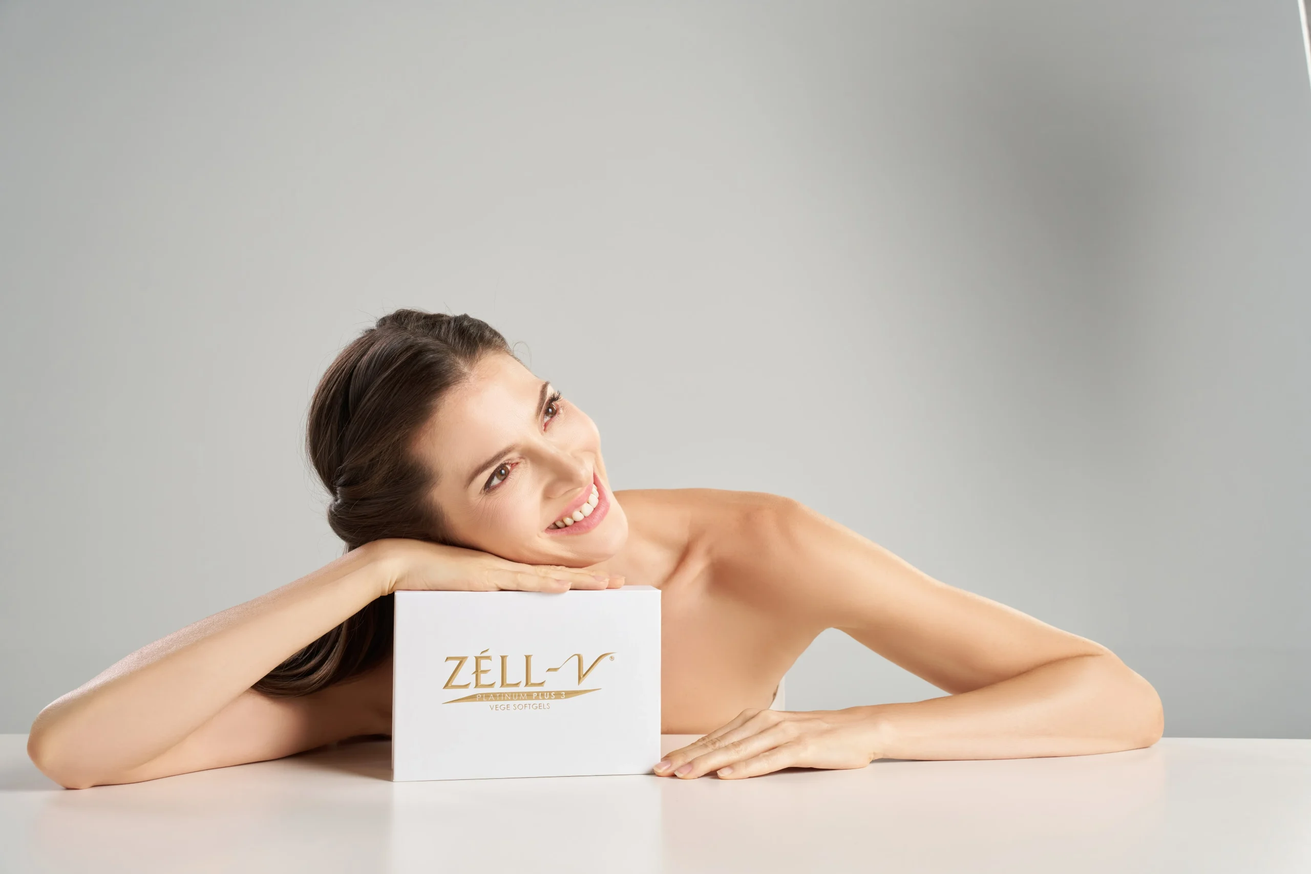 Woman smiling with ZÉLL-V product, representing the benefits of women’s health enhancement at V Wellness — helping women manage stress, energy, and hormonal balance.